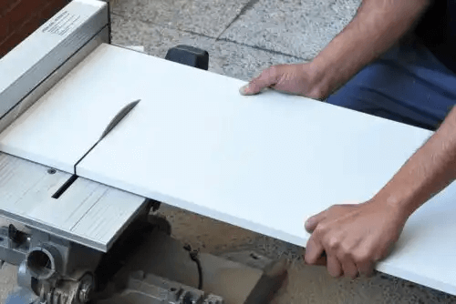 person sågar material för köksskåp