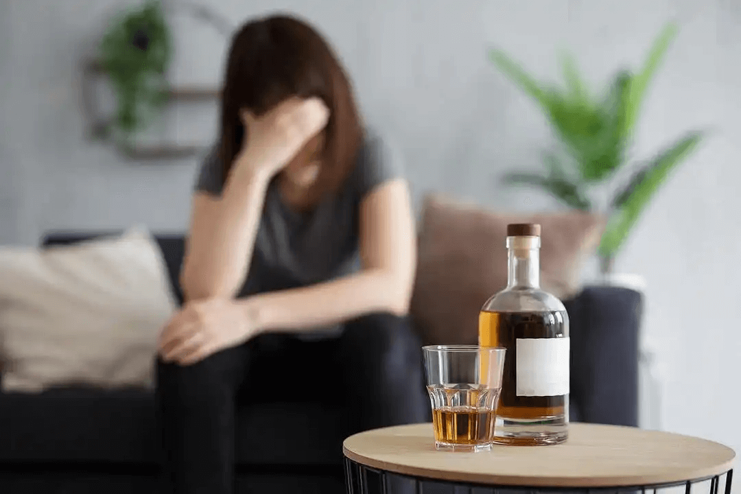 alkohol och diabetes: kvinna håller för ögonen i närheten av alkohol