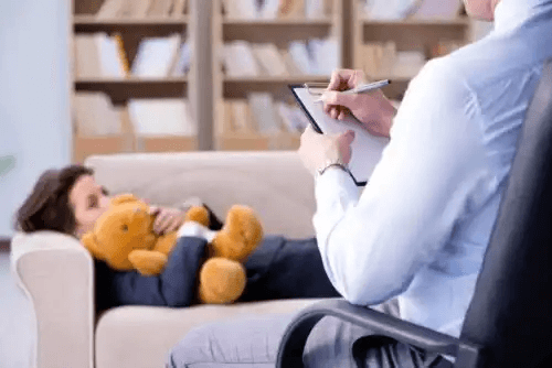 Sandlådeterapi för person på soffa med nalle