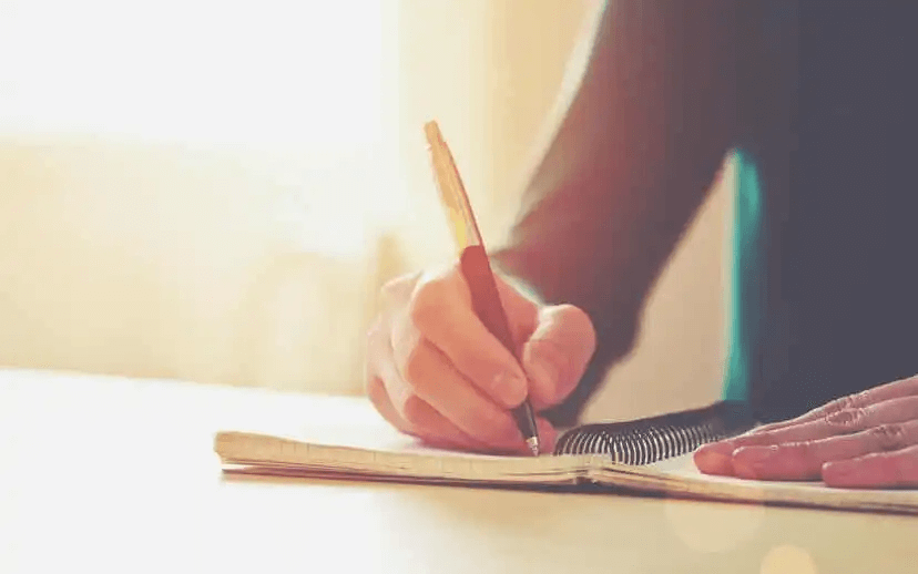 kvinna skriver i anteckningsbok
