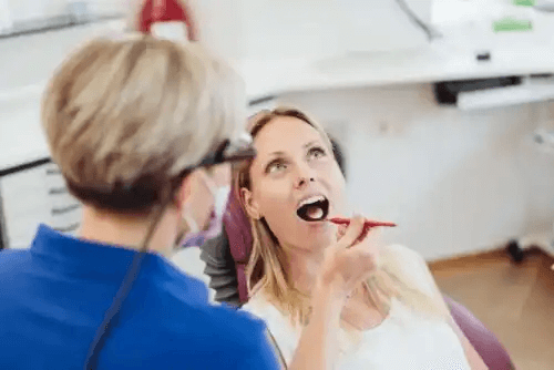 tandläkare undersöker patient för periimplantit