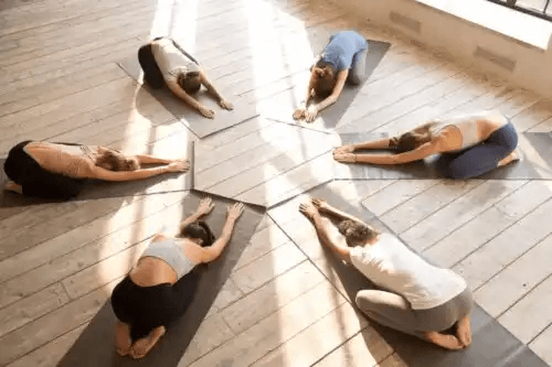 kvinnor utför Postpartum-yoga