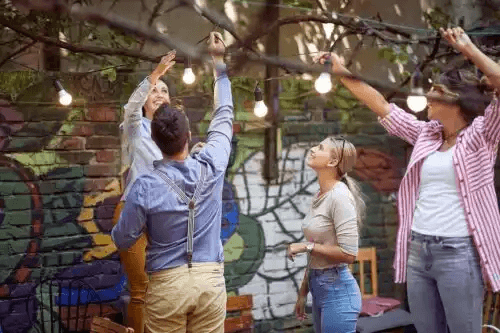 personer hänger upp belysning för en sommarfest