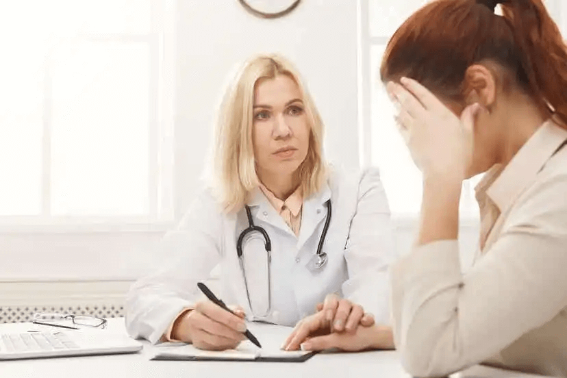 läkare pratar med kvinna om falsk menstruation