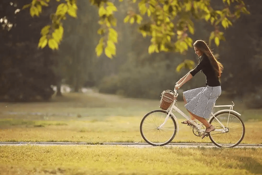 kvinna cyklar i park