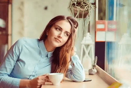 En kvinna tänker med kaffe.