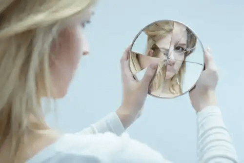 kvinna med trasig spegel