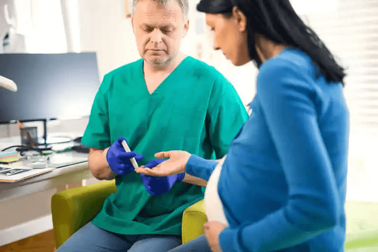En läkare som mäter blodsockret hos en gravid kvinna.