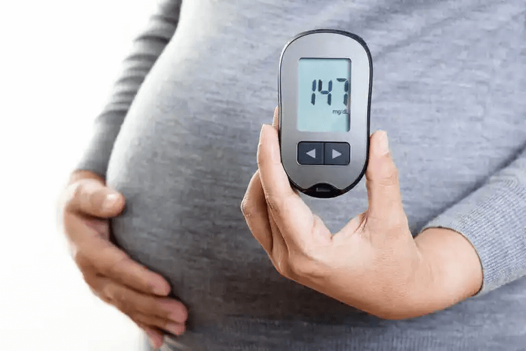 En gravid kvinna visar sin blodsockernivå på 147.