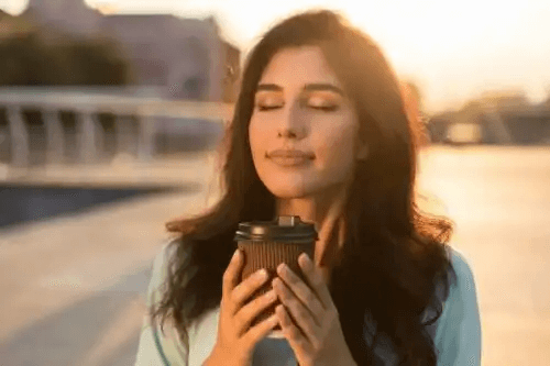 En kvinna som håller en kopp kaffe