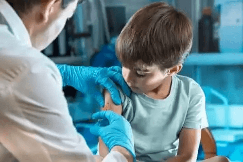 En läkare som vaccinerar en ung pojke.