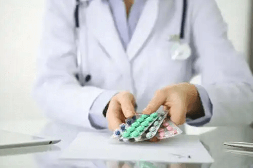 En läkare som ger en patient en mängd olika mediciner.