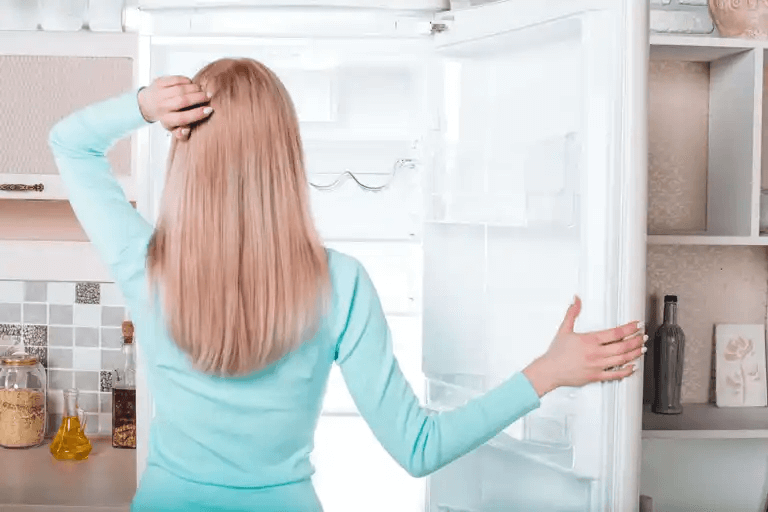 En kvinna tittar på sin frys.