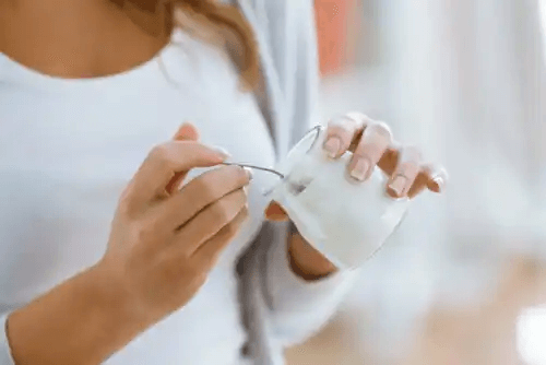 Kvinna som äter yoghurt