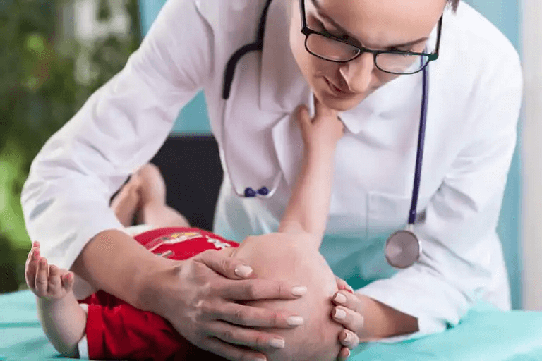 En läkare som kontrollerar en babys huvud.