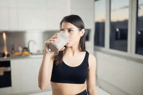 En kvinna som dricker en proteinshake