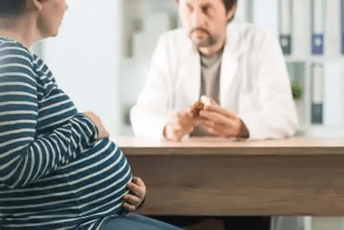 En gravid kvinna pratar med sin läkare om medicinering.