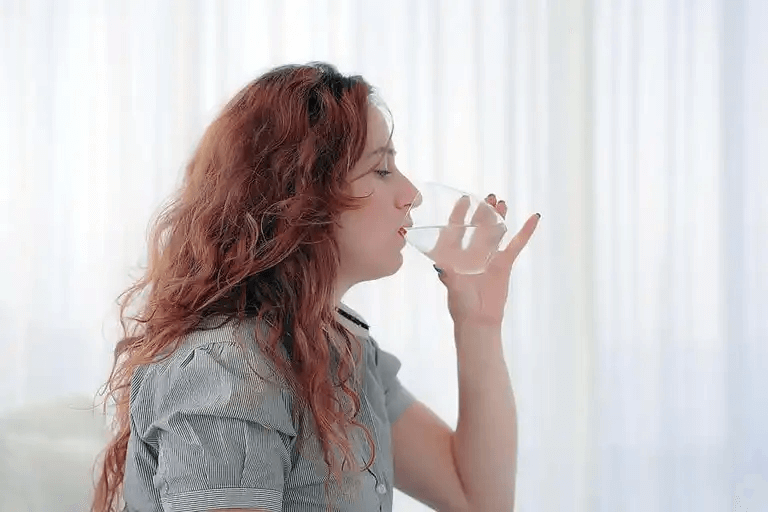 En kvinna som dricker vatten