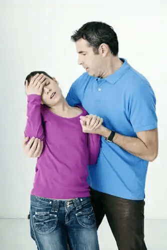 En man håller upp en person som håller på att svimma.