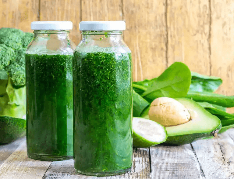 Två glasflaskor med grön juice.