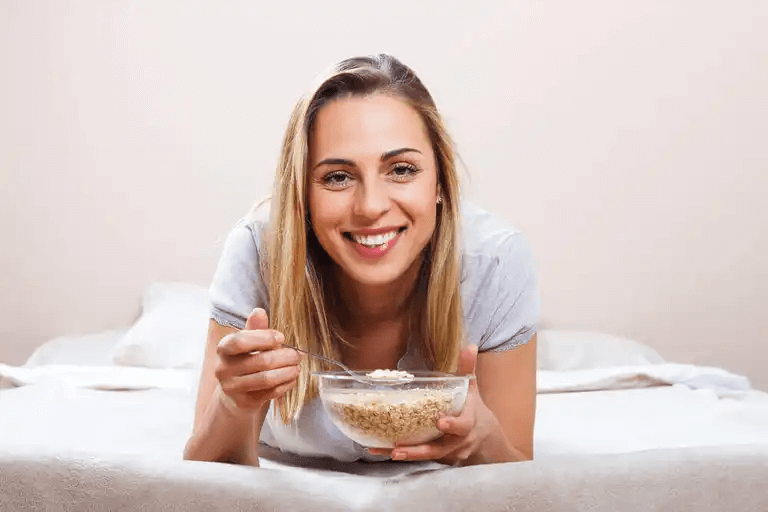 En kvinna som äter en skål med flingor.