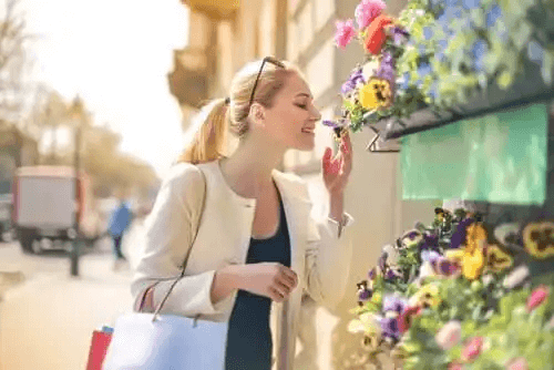 En person som luktar blommor.