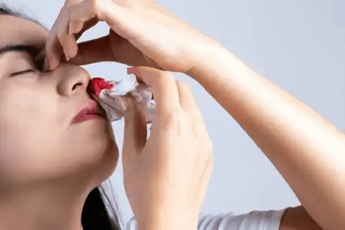 En kvinna som försöker stoppa näsblod