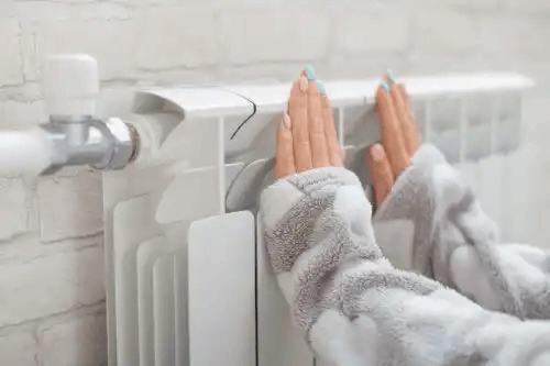 En person som värmer sina händer.