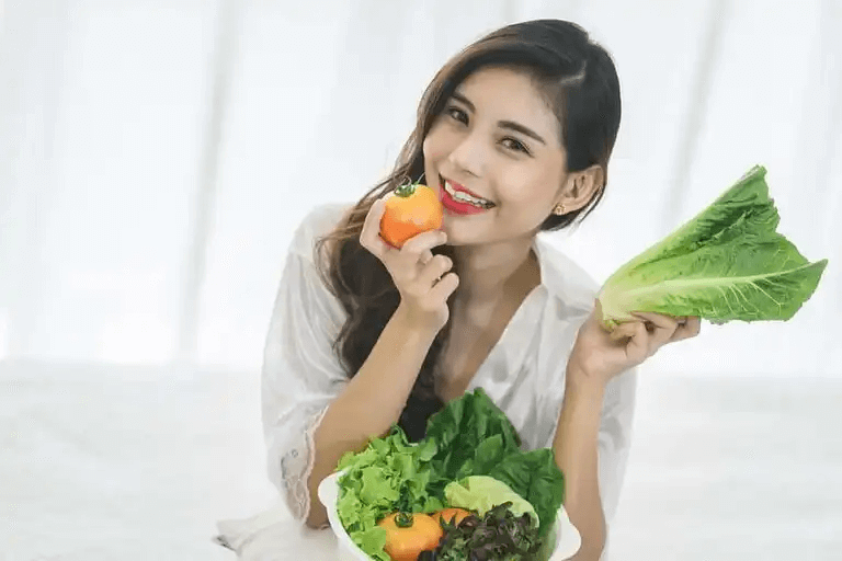 En kvinna som äter färska grönsaker.