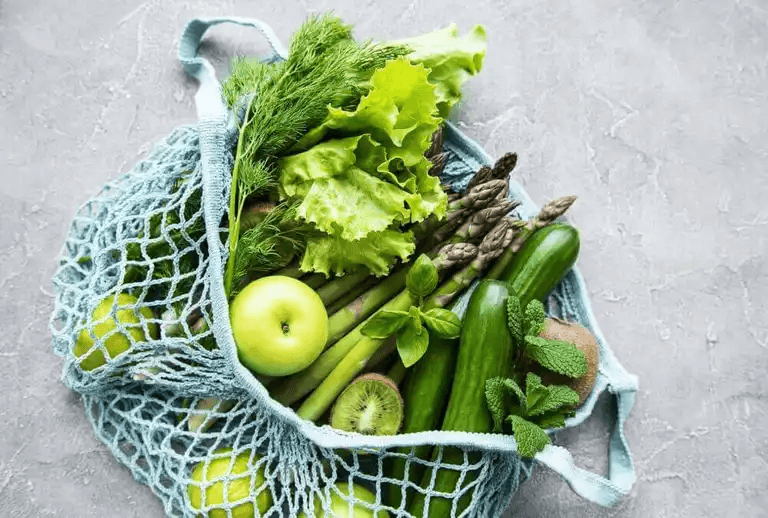 En påse med grön frukt och grönsaker.