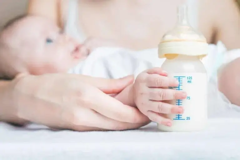 Bebis med nappflaska i handen.