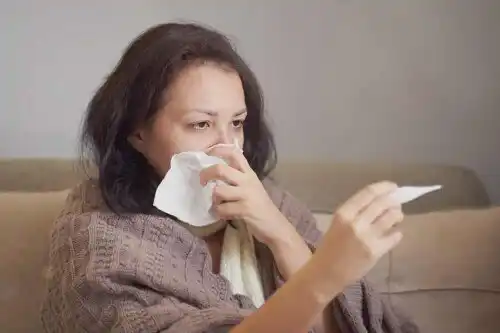 Förkyld kvinna med feber.
