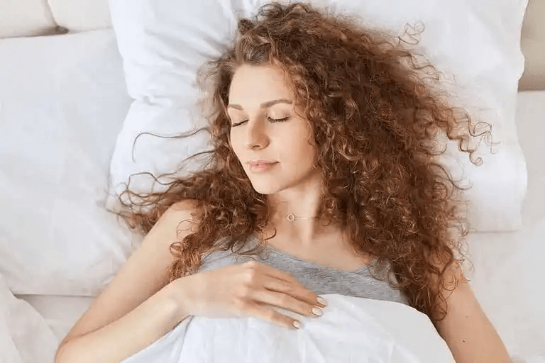 En kvinna sover i sin säng