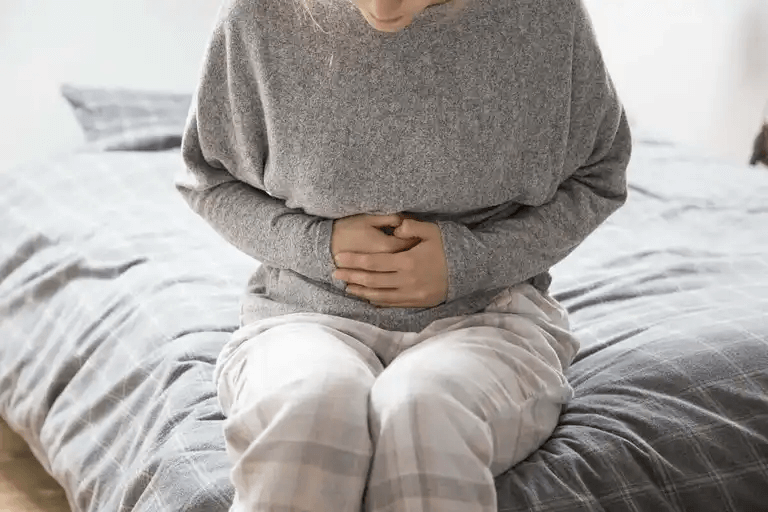 En kvinna med ont i magen behöver medicin mot förstoppning