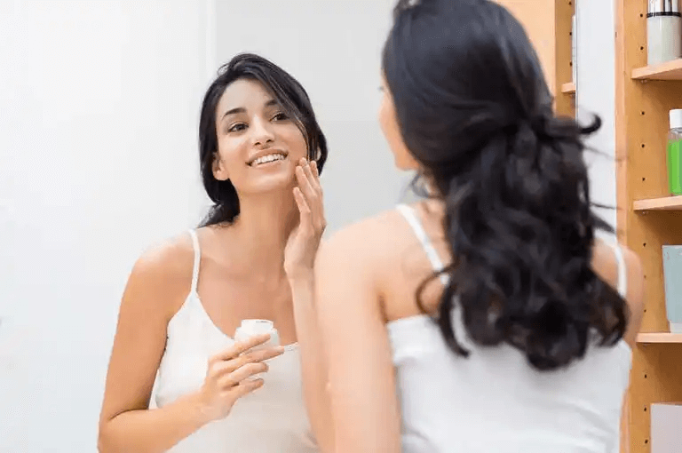 En kvinna får ansiktskräm på som en del av en kosmetisk rutin 