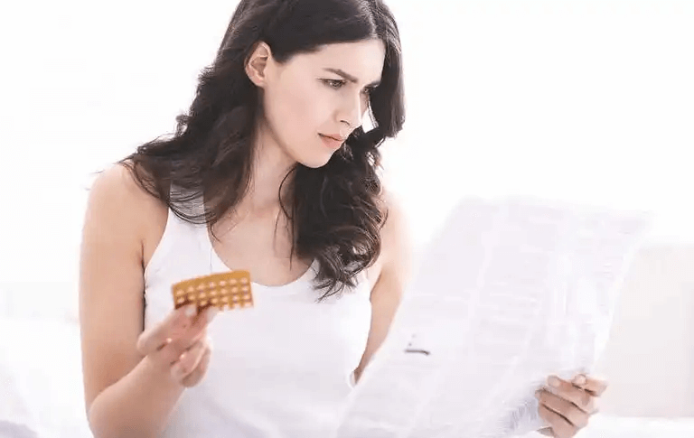 En kvinna som läser information om hennes p-piller.