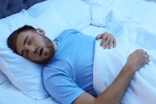 En man sover med öppen mun