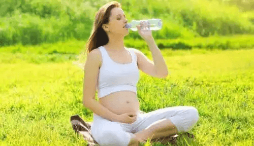 En gravid kvinna som dricker vatten