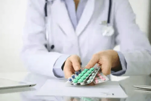En läkare som håller i några piller.