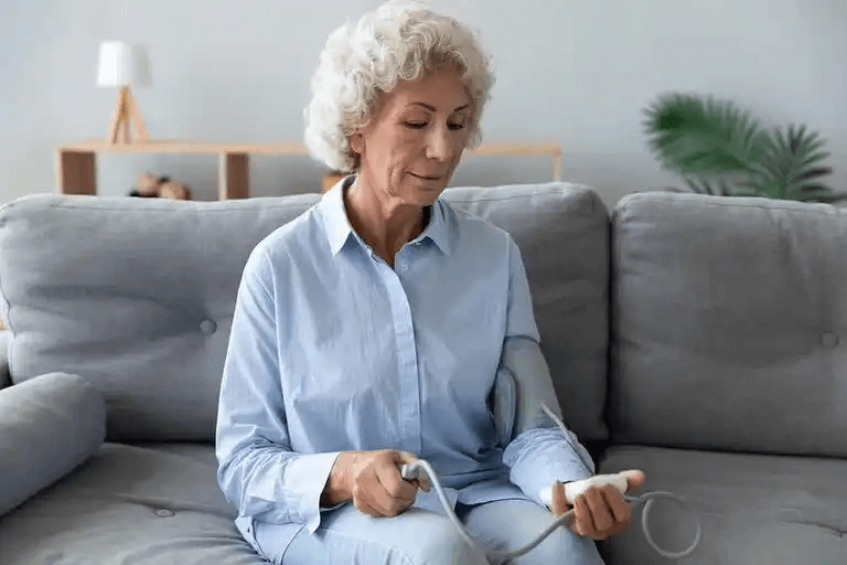 En äldre person som sitter i en soffa