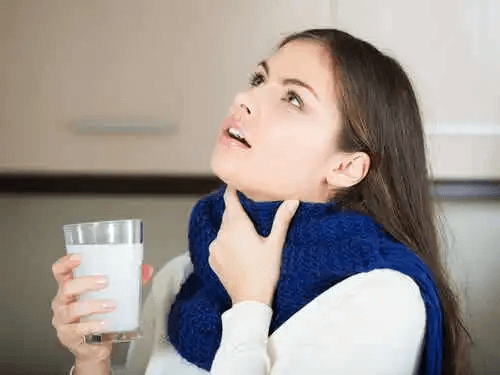 Kvinna använder munvatten mot ont i halsen
