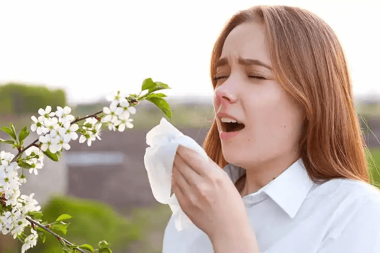 Kvinna vid blomma nyser och behöver flixonas