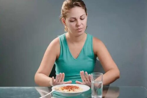 En kvinna som tackar nej till en tallrik pasta.