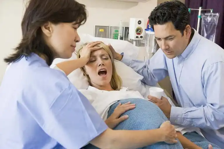 Kvinna är på väg att föda barn på sjukhus.