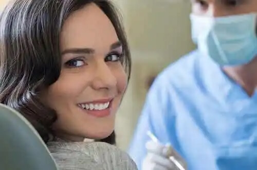 En kvinna som rengör sina tänder hos tandläkaren.