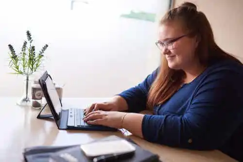 Överviktig kvinna jobbar på datorn.