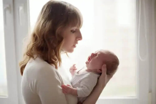 En bebis som gråter i sin mammas armar.