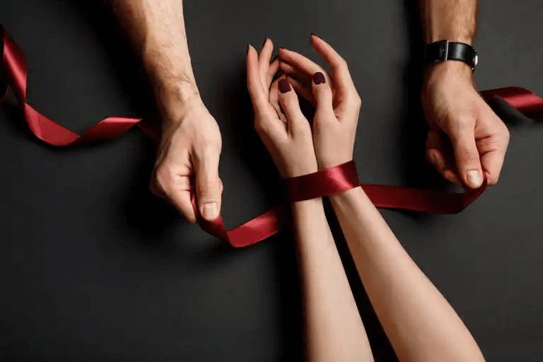 Man knyter kvinnans händer som en illustration av relationer av dominans och underkastelse