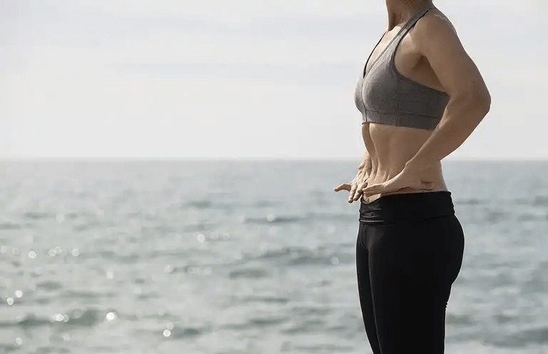 Kvinna som utför low pressure fitness utomhus