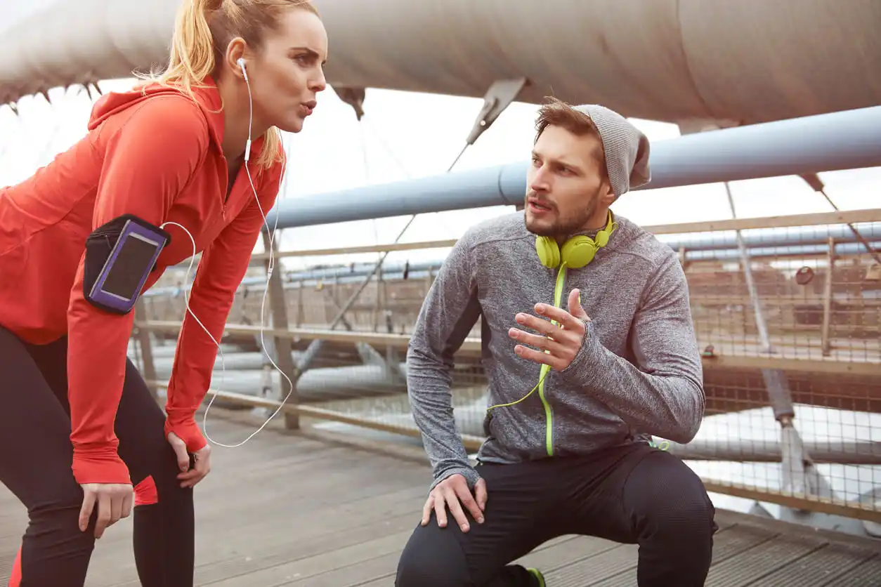 Kvinnan får tal från mannen under löpningen för att förbättra sportprestanda